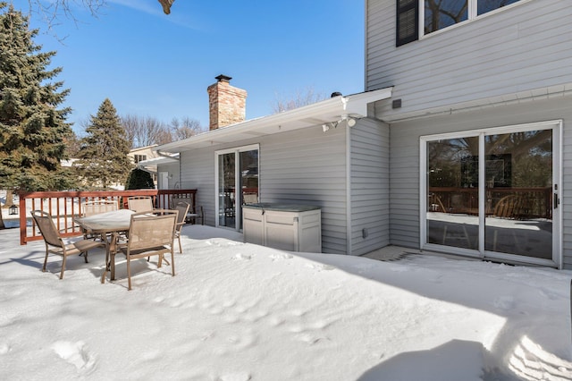 snow covered deck featuring outdoor dining space