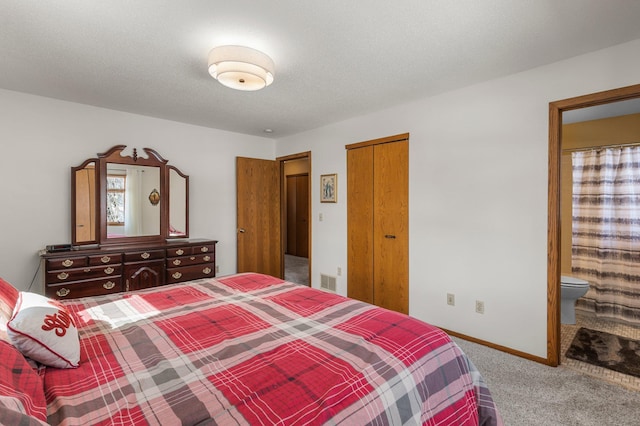 bedroom featuring visible vents, a textured ceiling, connected bathroom, carpet floors, and baseboards