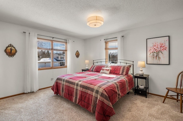 bedroom with multiple windows, carpet floors, a textured ceiling, and baseboards