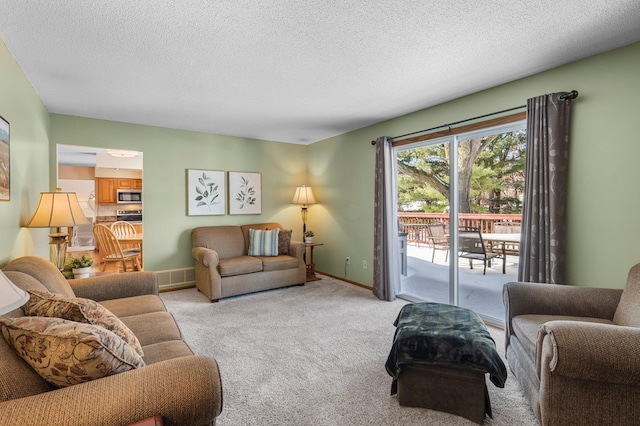 living area with light colored carpet, a textured ceiling, and baseboards