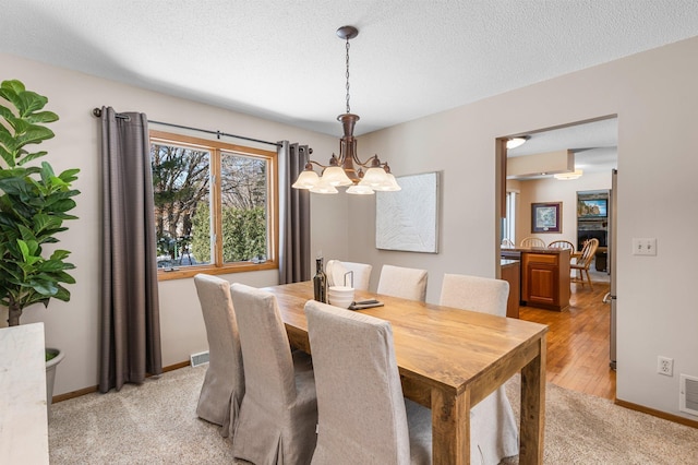 dining space featuring visible vents, baseboards, and a textured ceiling