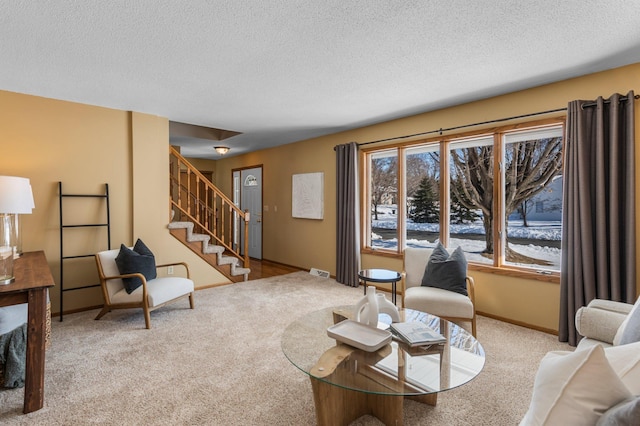 living room featuring stairs, baseboards, carpet floors, and a textured ceiling