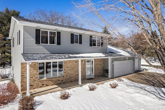 traditional-style home featuring brick siding, a shingled roof, a porch, driveway, and an attached garage