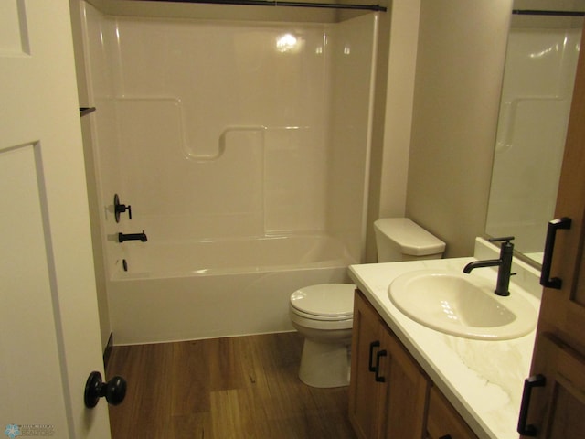 full bathroom with hardwood / wood-style floors, vanity, shower / bathtub combination, and toilet