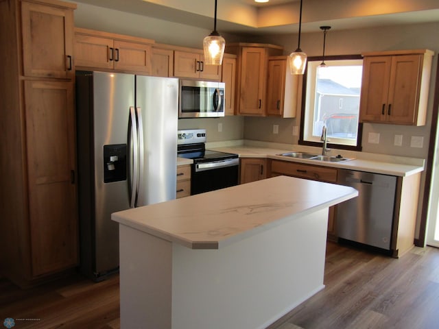 kitchen featuring sink, dark hardwood / wood-style floors, appliances with stainless steel finishes, decorative light fixtures, and a kitchen island