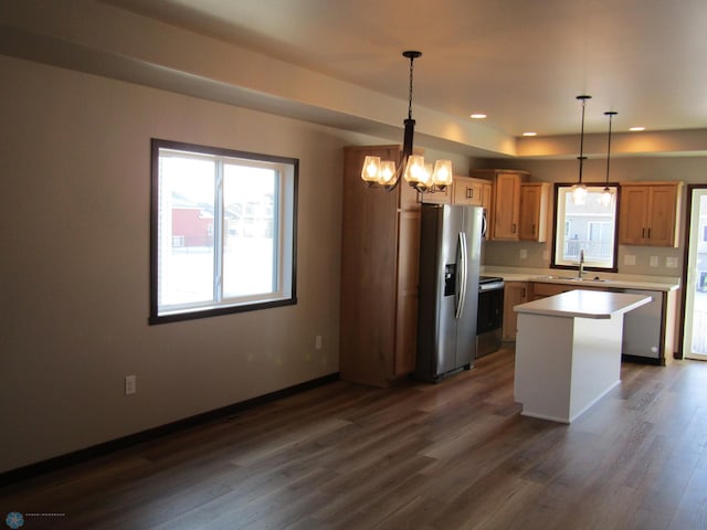 kitchen with a kitchen island, a chandelier, decorative light fixtures, and appliances with stainless steel finishes