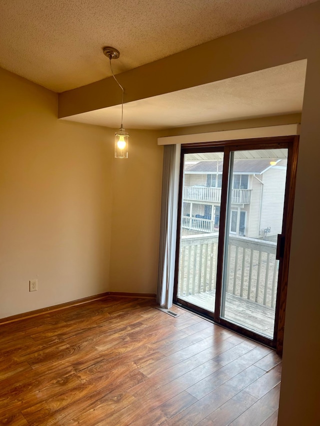 spare room with a textured ceiling and hardwood / wood-style flooring