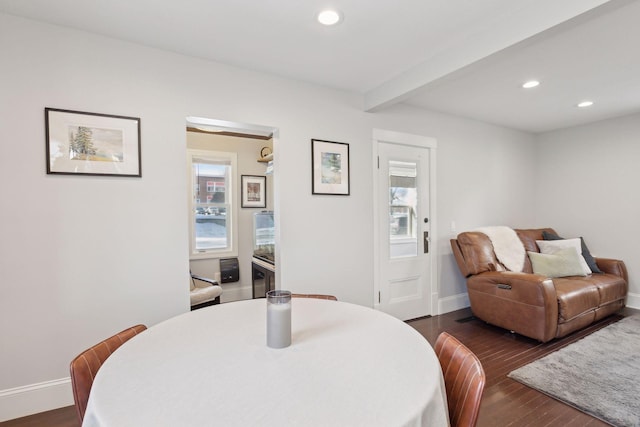 dining room featuring dark hardwood / wood-style flooring, beamed ceiling, and a healthy amount of sunlight