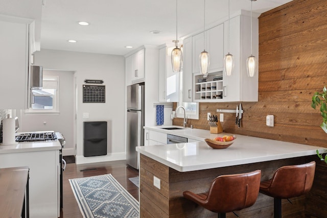 kitchen with pendant lighting, stainless steel appliances, sink, backsplash, and kitchen peninsula