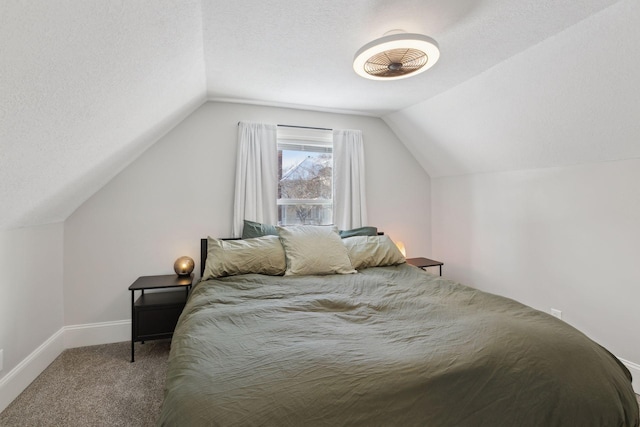 carpeted bedroom featuring lofted ceiling and a textured ceiling