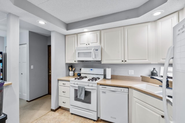 kitchen featuring a textured ceiling, sink, white cabinets, and white appliances