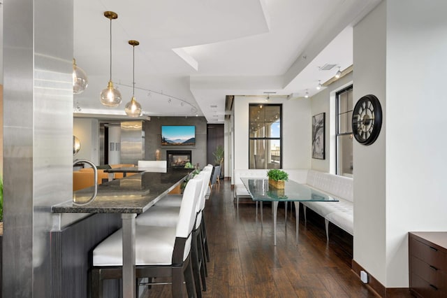 dining space with a fireplace and dark wood-type flooring