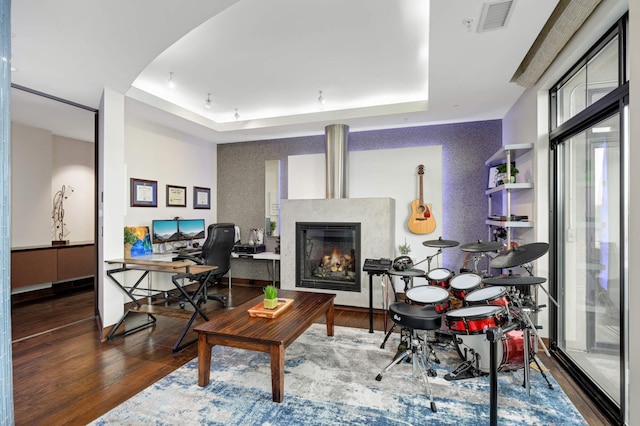 living room featuring a raised ceiling and hardwood / wood-style floors