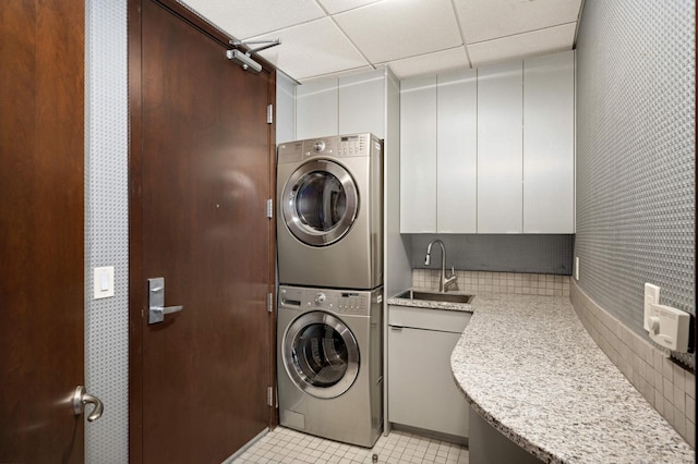 clothes washing area with sink and stacked washer / dryer