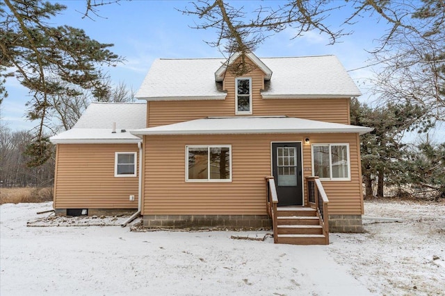 view of snow covered rear of property