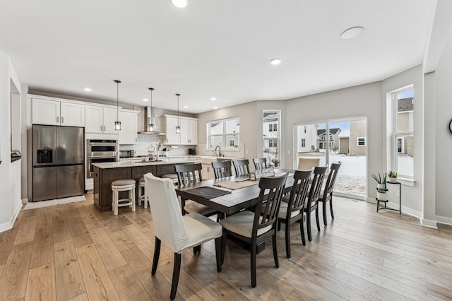 dining space with sink and light hardwood / wood-style flooring