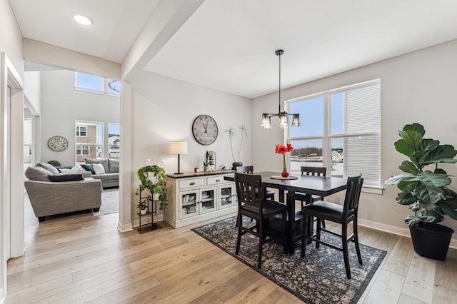 dining area with a notable chandelier and light hardwood / wood-style flooring