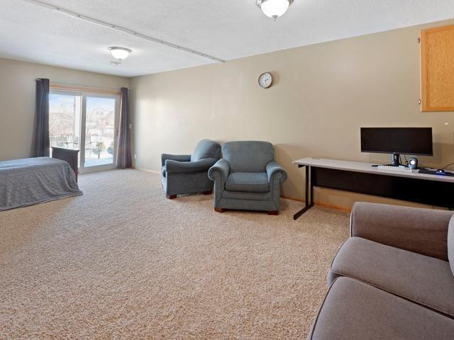 bedroom with light carpet, a textured ceiling, and access to outside