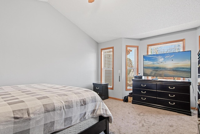 carpeted bedroom with vaulted ceiling and a textured ceiling