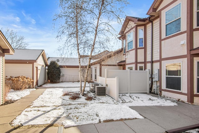 snow covered patio featuring central AC unit