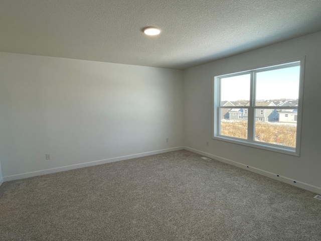 unfurnished room featuring carpet floors and a textured ceiling