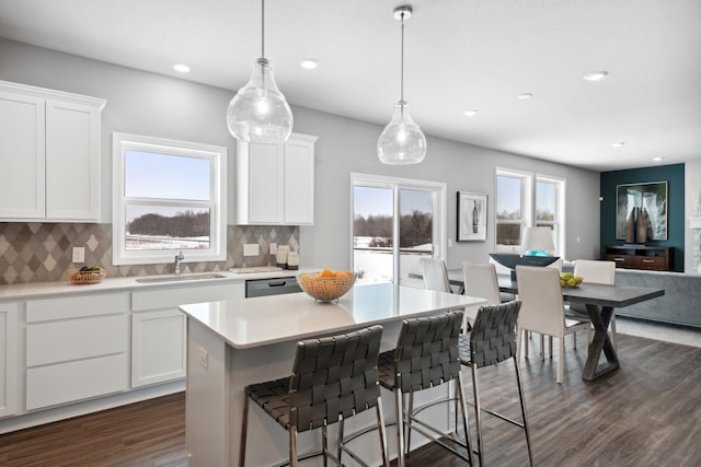 kitchen featuring hanging light fixtures, white cabinetry, sink, and decorative backsplash