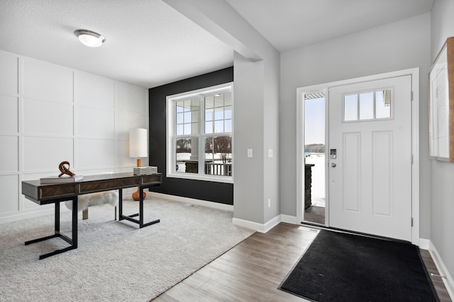 foyer entrance with hardwood / wood-style flooring and a textured ceiling