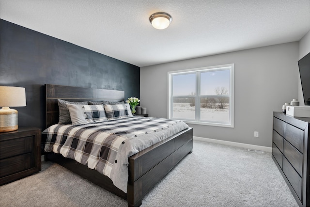 bedroom featuring light carpet and a textured ceiling