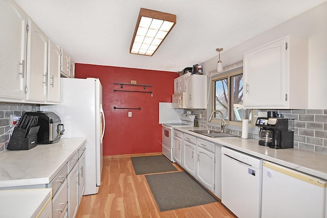 kitchen featuring tasteful backsplash, white cabinetry, and white appliances