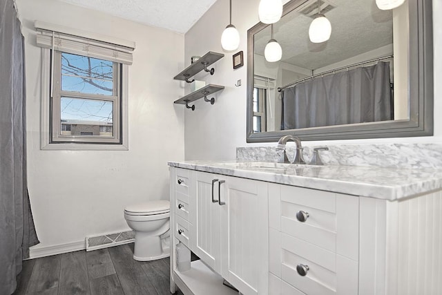 bathroom featuring vanity, toilet, and a textured ceiling