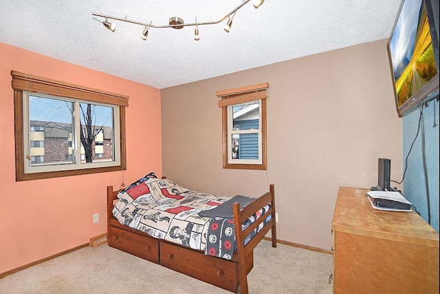 bedroom featuring light colored carpet and a textured ceiling