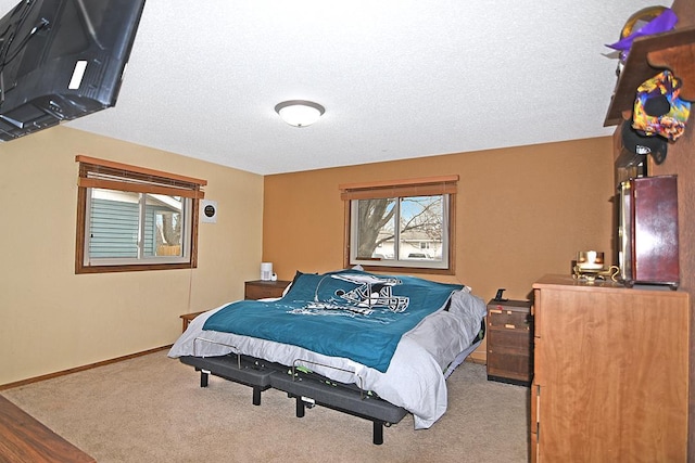 bedroom featuring light colored carpet and a textured ceiling