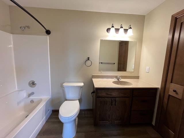 full bath with vanity, wood finished floors, baseboards, bathtub / shower combination, and toilet