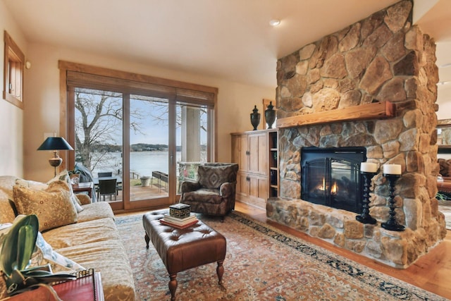 living room featuring a fireplace, hardwood / wood-style floors, and a water view