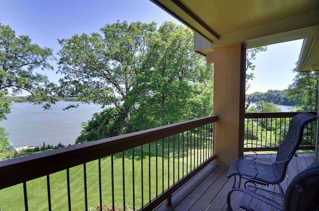 wooden terrace featuring a water view and a yard