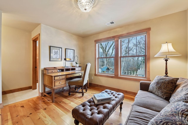 office space with a chandelier and light wood-type flooring