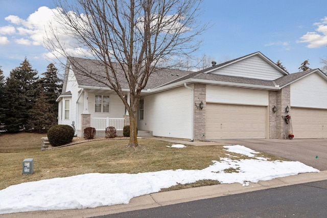 ranch-style house featuring an attached garage, covered porch, a front lawn, aphalt driveway, and brick siding