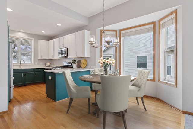 dining room with recessed lighting, baseboards, light wood-style floors, and a chandelier