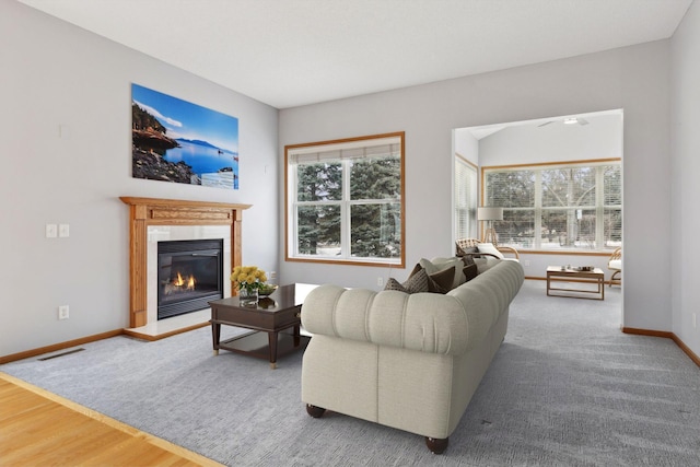 living room with visible vents, plenty of natural light, baseboards, and a glass covered fireplace