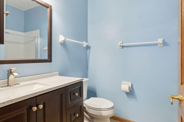 full bath featuring a shower with door, toilet, and vanity