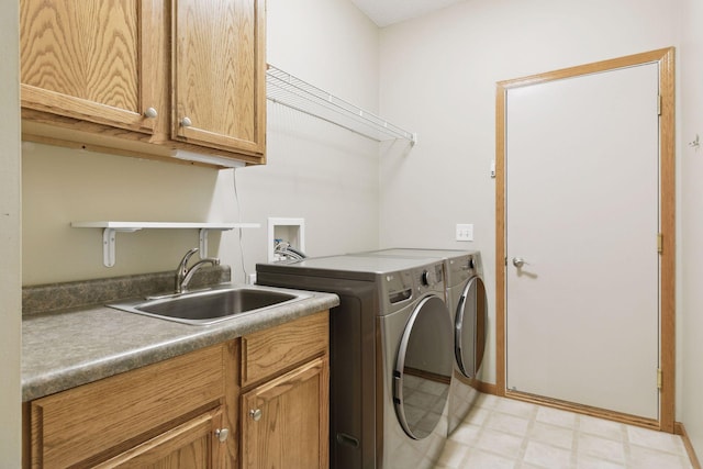 clothes washing area with a sink, cabinet space, light floors, and washing machine and clothes dryer