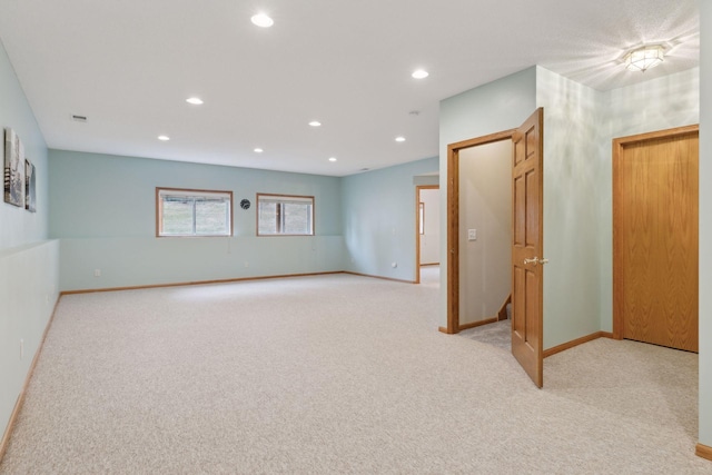 unfurnished room with recessed lighting, baseboards, and light carpet