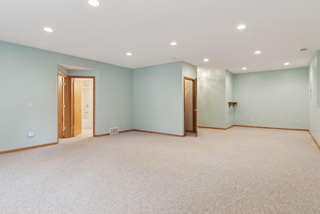 spare room with carpet flooring, recessed lighting, visible vents, and baseboards