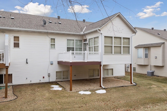 back of property with a yard, central AC unit, and a shingled roof