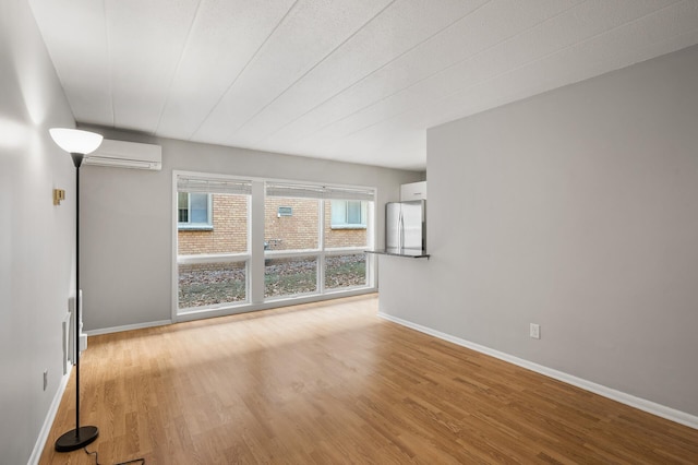 empty room featuring light hardwood / wood-style flooring and a wall unit AC