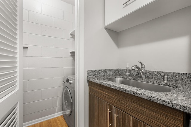 washroom with washer / dryer, light wood-type flooring, and sink