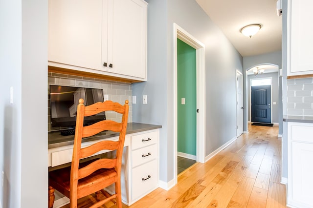 kitchen with light hardwood / wood-style flooring, decorative backsplash, and white cabinets