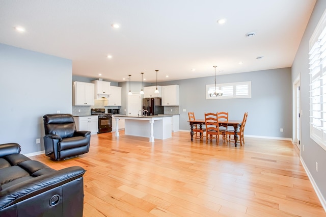 living room featuring a notable chandelier and light wood-type flooring