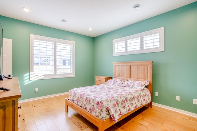 bedroom featuring multiple windows and light hardwood / wood-style flooring