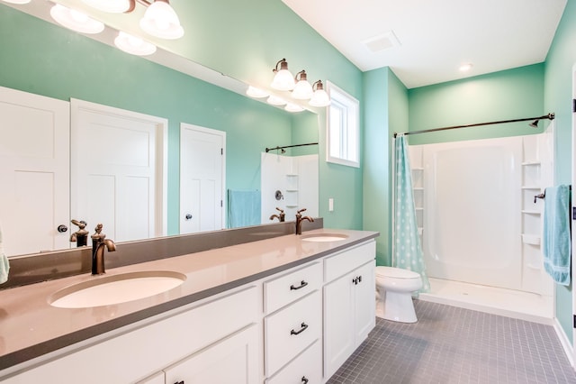 bathroom featuring tile patterned flooring, vanity, toilet, and walk in shower